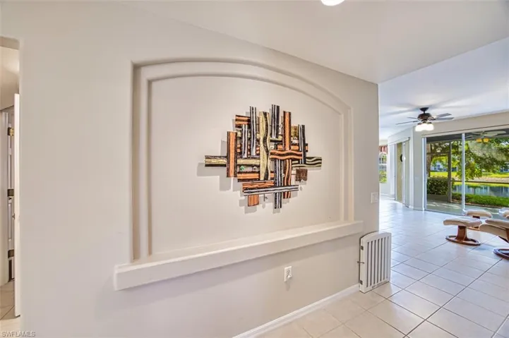 Hallway with light tile patterned floors and baseboards