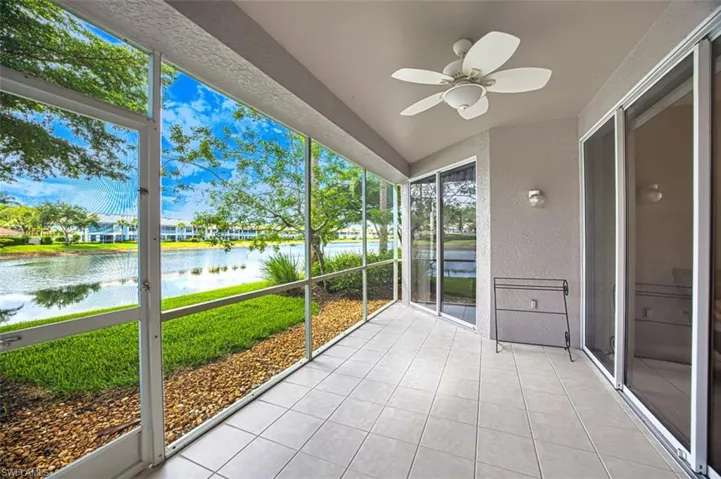 Unfurnished sunroom with a water view, a ceiling fan, and vaulted ceiling