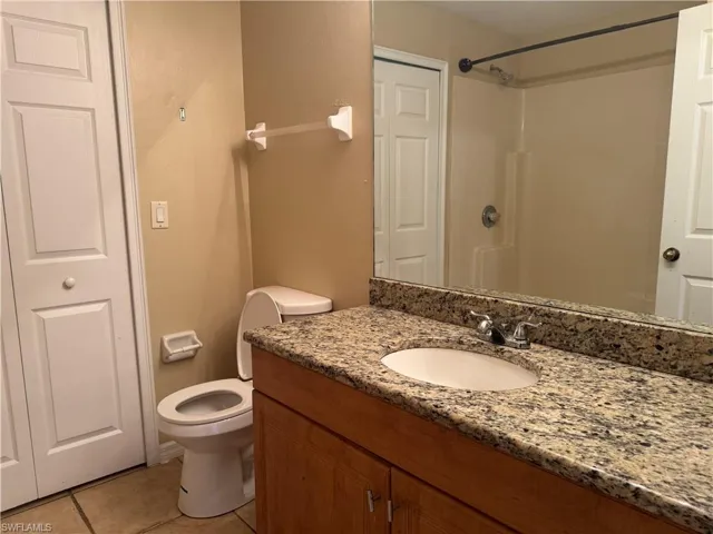 Bathroom featuring vanity, tile patterned flooring, and a shower