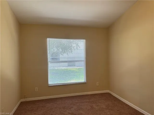 Carpeted spare room with baseboards