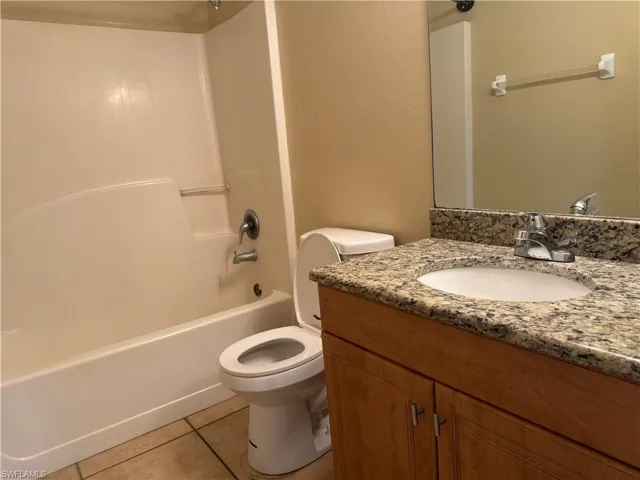 Full bath with tile patterned floors, vanity, and tub / shower combination