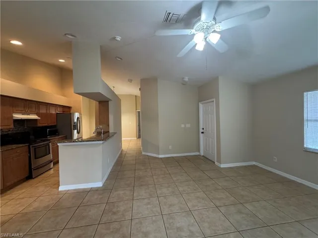 Kitchen with appliances with stainless steel finishes, light tile patterned floors, a ceiling fan, a peninsula, and recessed lighting