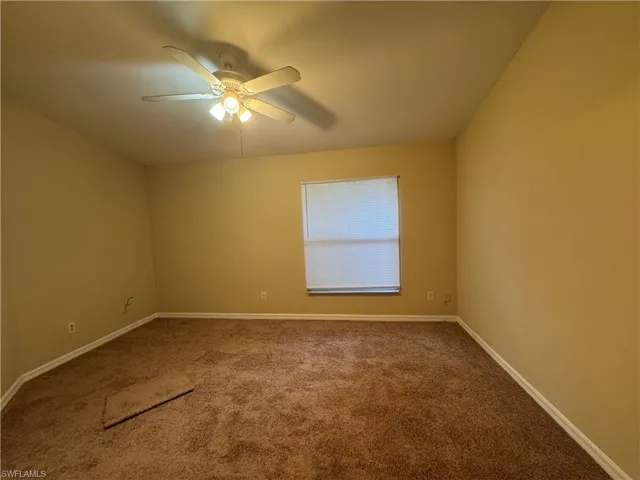 Spare room featuring carpet flooring and a ceiling fan