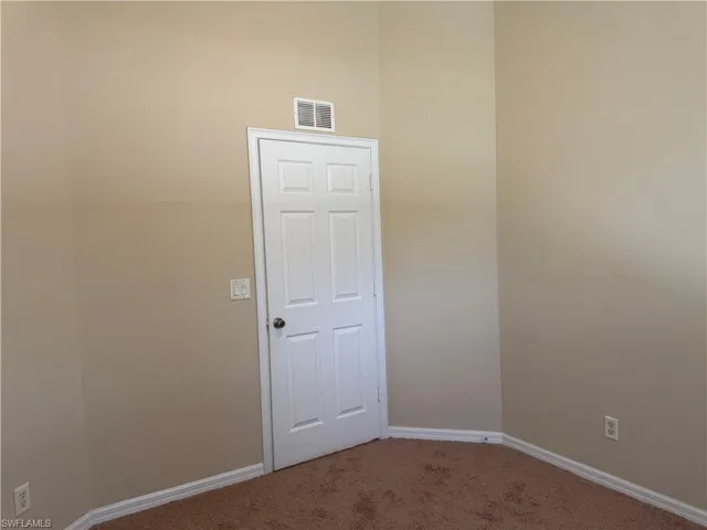 Carpeted empty room with baseboards