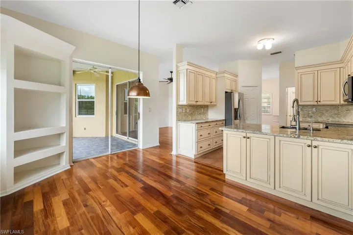 Kitchen featuring light cabinetry, a stone countertop, and wood-finish flooring