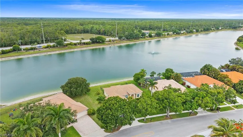 Waterfront property featuring direct access to the canal, a tiled roof, and a mature treed lot