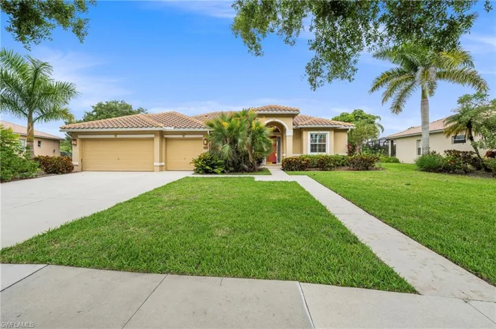 Single-story residence featuring a tile roof, stucco exterior, and an arched entry with a red door