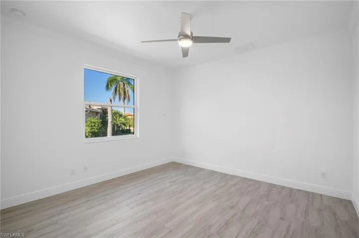 Empty room with light wood-type flooring, ornamental molding, and a ceiling fan