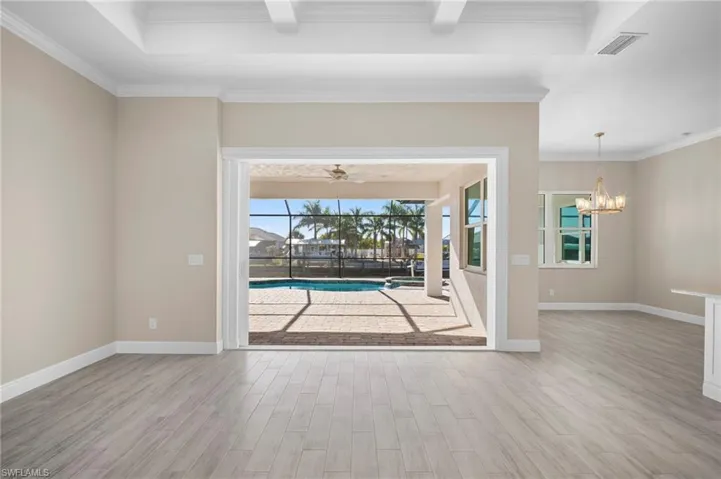 Spare room with a sunroom, crown molding, light wood-type flooring, and ceiling fan