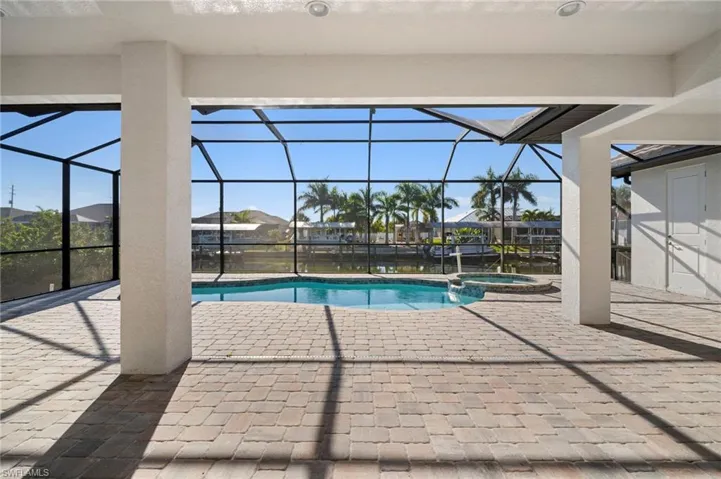 View of swimming pool with a patio, a sunroom, glass enclosure, and a pool with connected hot tub