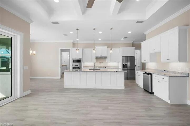 Kitchen with white cabinets, recessed lighting, hanging light fixtures, a chandelier, and appliances with stainless steel finishes