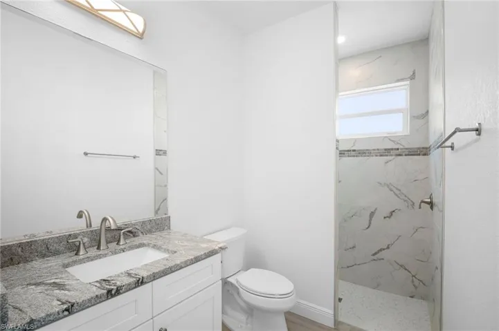 Full bath with vanity and a marble finish shower
