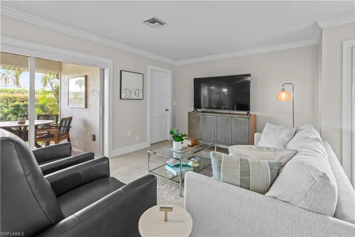 Living room with ornamental molding and wood finished floors