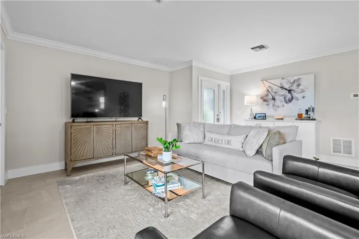 Living area featuring ornamental molding and baseboards