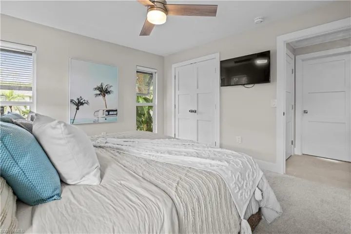 Carpeted bedroom with ceiling fan and baseboards