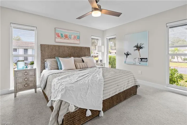Carpeted bedroom with ceiling fan and baseboards