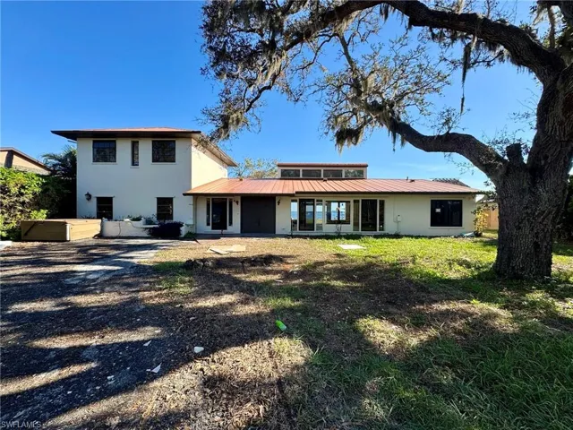 Rear view of house featuring a lawn