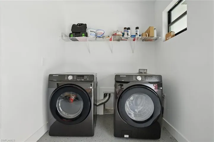 Washroom featuring washer and dryer and baseboards