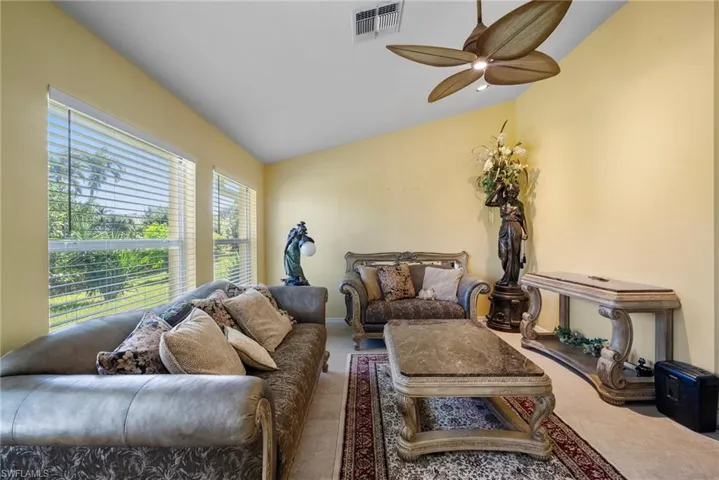 Living room featuring ceiling fan and lofted ceiling