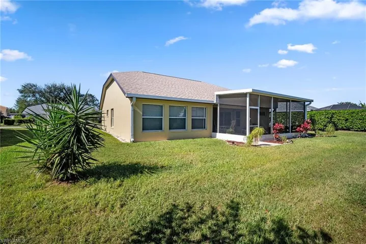Back of house featuring a sunroom and a yard