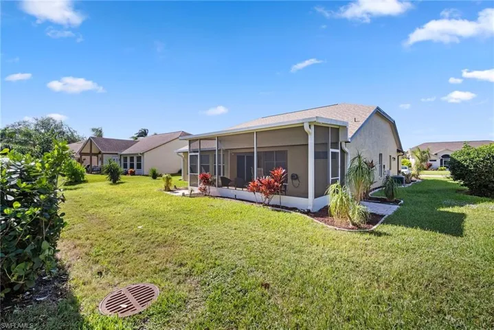 Back of house featuring a lawn and a sunroom