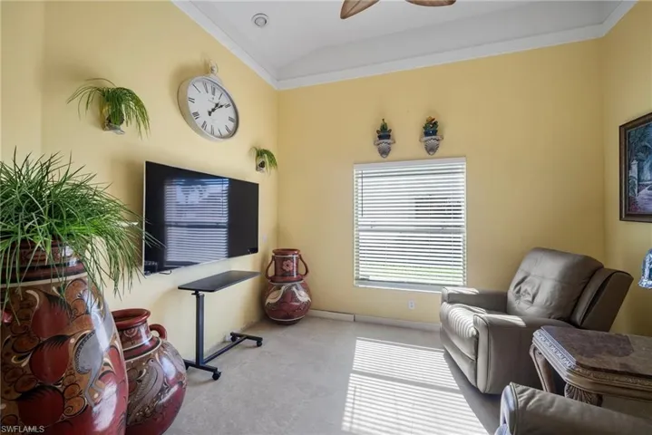 Sitting room with vaulted ceiling, ceiling fan, and crown molding