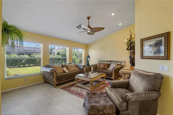 Living room featuring vaulted ceiling and ceiling fan