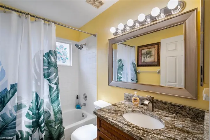 Full bathroom featuring vanity, toilet, and shower / bath combo with shower curtain
