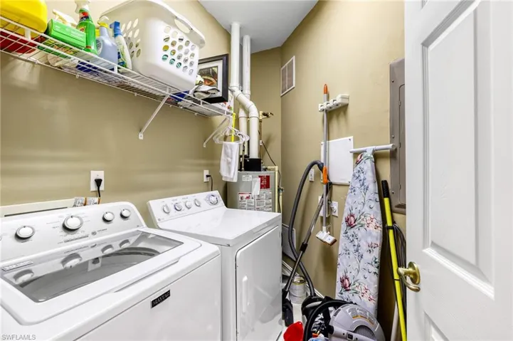 This convenient in-unit laundry room is equipped with a full-sized washer and dryer and ample storage.