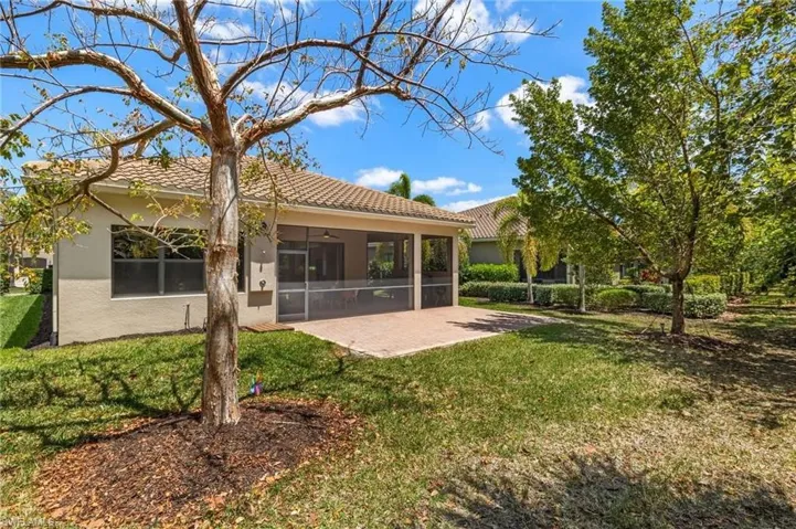 Rear view of house featuring a sunroom and a yard