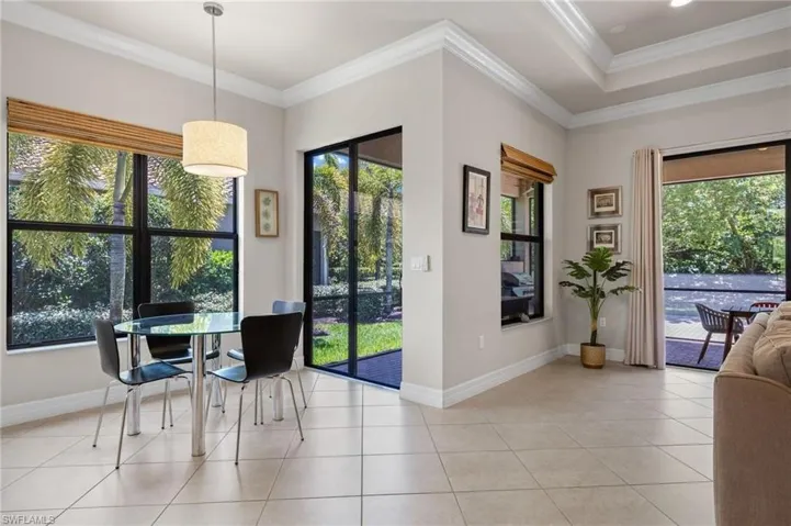 Dining area featuring plenty of natural light, light tile flooring, and crown molding