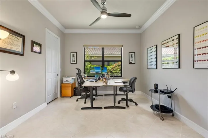 Tiled home office with ornamental molding and ceiling fan