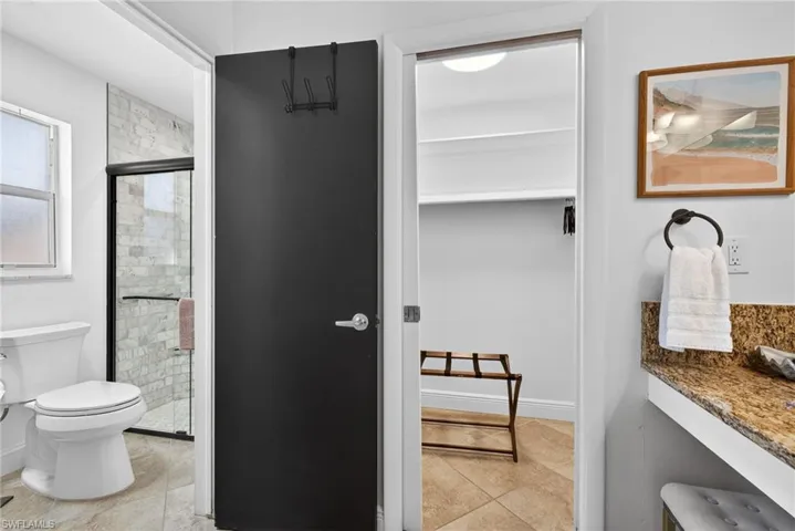 Bathroom with a shower stall, vanity, and light tile patterned flooring