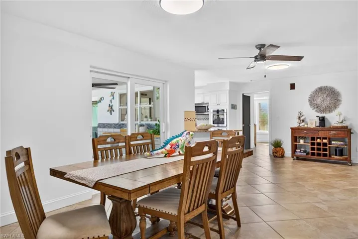 Dining space featuring a ceiling fan and light tile patterned flooring