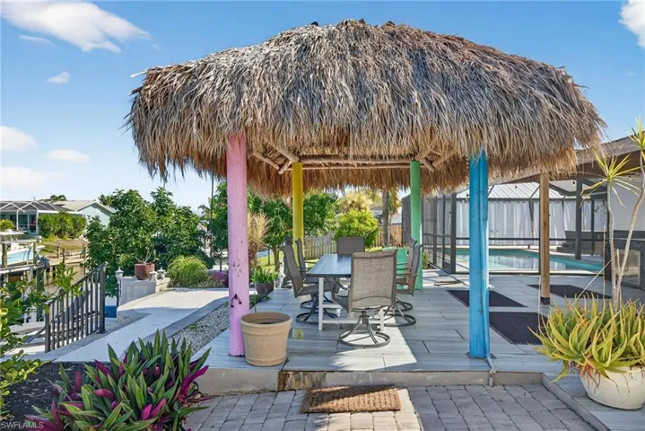 View of patio with a gazebo, a wooden deck, and outdoor dining space