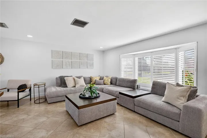 Living room with light tile patterned floors and recessed lighting