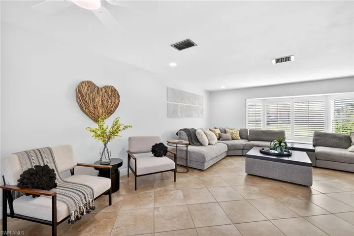 Living area with a ceiling fan, recessed lighting, and light tile patterned floors