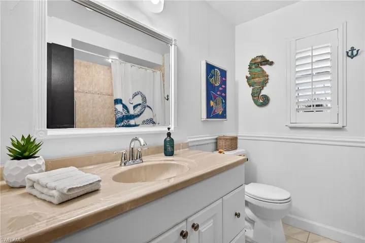 Bathroom with vanity, a shower with curtain, wainscoting, and light tile patterned floors