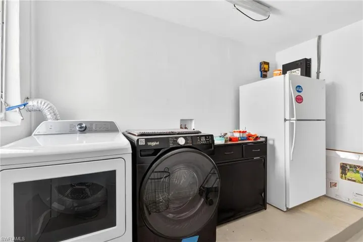 Laundry room featuring finished concrete flooring and washing machine and dryer