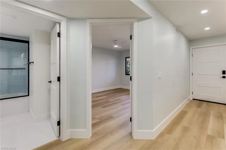 Corridor with light wood-style flooring and recessed lighting