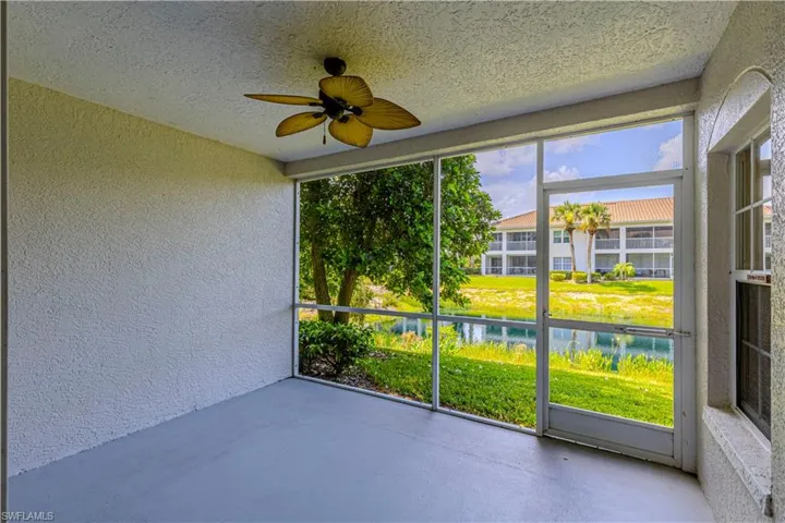 Unfurnished sunroom with a ceiling fan and a water view