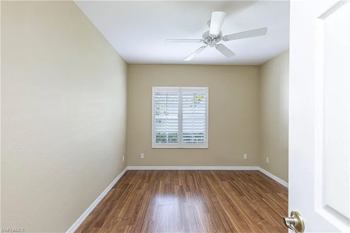 Spare room featuring dark wood-style flooring and ceiling fan