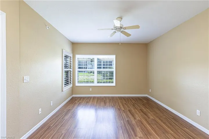 Empty room with a ceiling fan, wood finished floors, a textured wall, and a textured ceiling