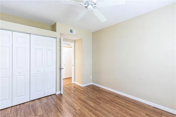 Unfurnished bedroom featuring wood finished floors, a closet, and ceiling fan