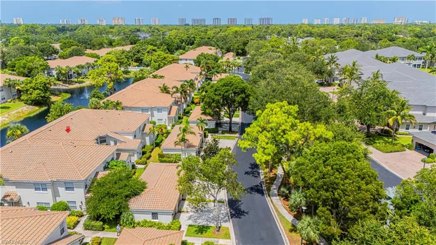 Aerial perspective of suburban area featuring city skyline and a tree filled landscape
