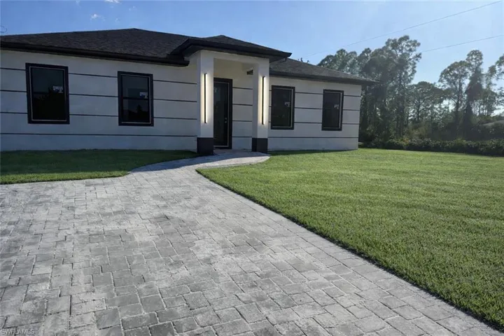 View of front of home with a front yard and roof with shingles