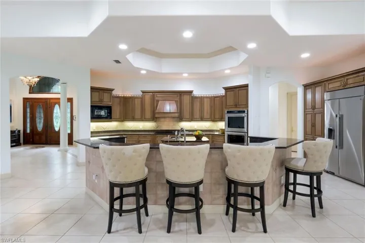 Open floor plan with spacious kitchen, including counter seating, kitchen island, stainless steel appliances, and plenty of counter space for the creative cook.