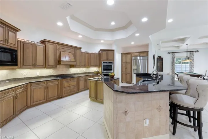 Open floor plan with spacious kitchen, including counter seating, kitchen island, stainless steel appliances, and plenty of counter space for the creative cook.