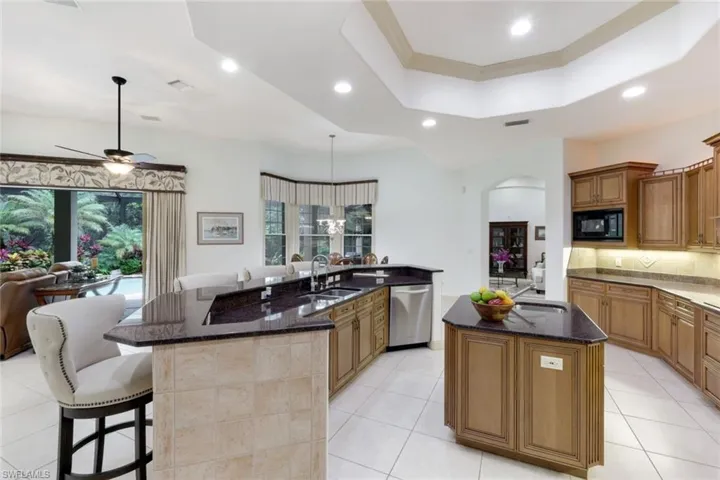 Open floor plan with spacious kitchen, including counter seating, kitchen island, stainless steel appliances, and plenty of counter space for the creative cook.