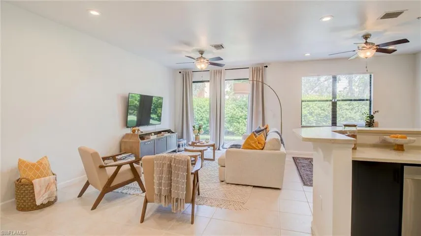 Living room with a ceiling fan, light tile patterned floors, and recessed lighting